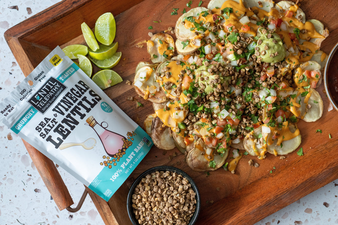 An appetizer platter with nachos made from air-fried potato rounds, and loaded with toppings such as guacamole, vegan cheese, pico de gallo, and Lentil Telepathy Sea Salt and Vinegar Crunchy Lentils