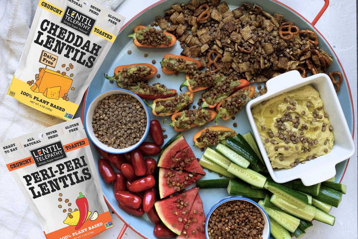 Lentil Telepathy Cheddah and Peri-Peri packages on the original vibrant crunchy lentil snack board, with ready to eat, all natural, never fried and gluten free package callouts